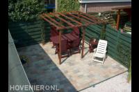 Terras van klinkers in pastelkleuren met houten pergola