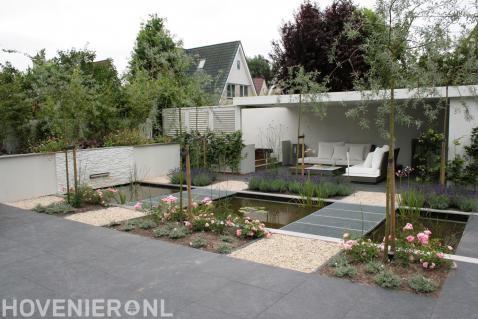 Moderne tuin met bestrating, vijver en overkapping