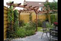 Tuin met schutting, houten pergola's en terras