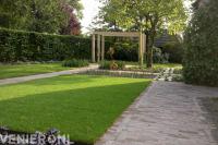 Tuin met gazon en houten pergola