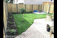 Tuinaanleg met hout beton schutting, gazon en beplanting in borders