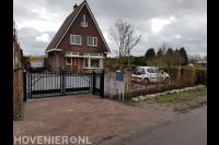 Voortuin met sierpoort en oprit van grind