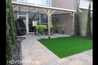 Achtertuin met terrasoverkapping en kunstgras