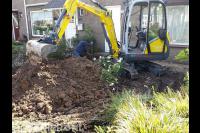 Grondwerk in tuin met minikraan