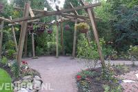 Speelse houten pergola met hangende bloembakken 2