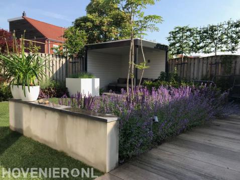 Moderne tuin met overkapping en witte bloempotten en plantenbakken 1