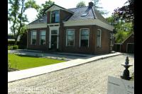 Voortuin met gazon en oprit van grind