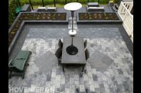 Strakke tuin met sierbestrating en verhoogde borders met beplanting