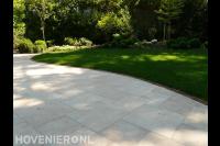 Bestrating van lichte siertegels bij gazon