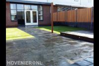 Tuinaanleg met bestrating van natuursteen en gazon