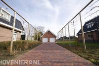 Leibomen langs oprit bestraat met klinkers