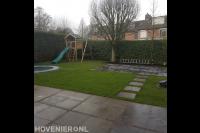 Kindvriendelijke tuin met terras, gazon, trampoline en speeltoestel
