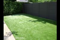 Tuinaanleg met kunstgras en betonschutting