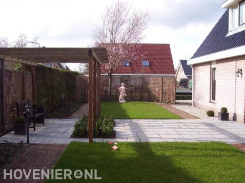 Tuin met houten pergola boven terras en gazon