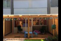 Houten overkapping met vlonder en kleurrijke verlichting