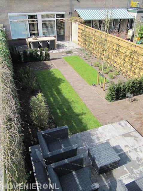 Achtertuin met terras, bestrating, gazon en haagplanten 1