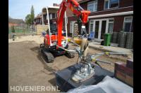 Grote tuintegels leggen met graafmachine