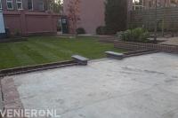 Terras van grote tegels en nieuw gazon van graszoden