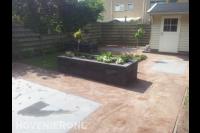 Achtertuin met bestrating, gazon en plantenbakken