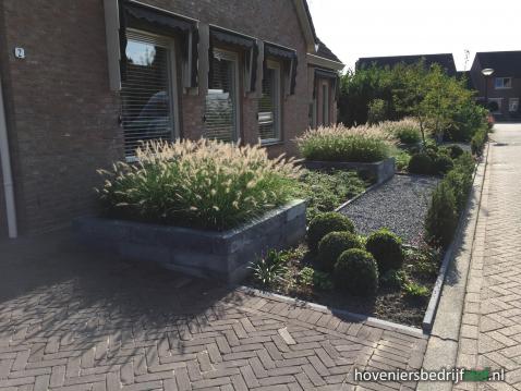 Voortuin met siergras in plantenbakken