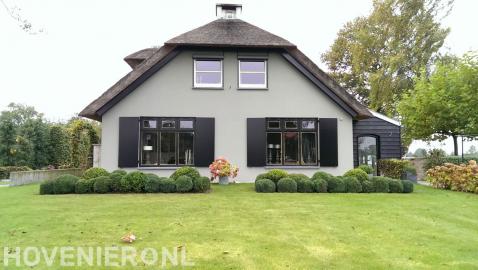 Boerderijtuin met gazon en buxusbollen