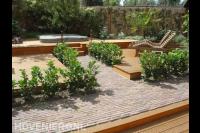 Tuinaanleg met houten vlonders, jacuzzi en haagplanten