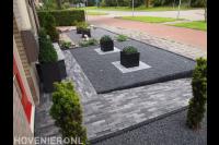 Onderhoudsarme voortuin met bestrating van grijze waaltjes en split