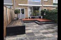 Tuinaanleg met houten vlonder en bestrating van natuursteen