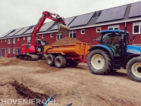 Grondwerkzaamheden met graafmachine en tractor met kipper