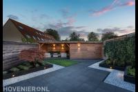 Tuinaanleg met bestrating, plantenbakken en schuurtje met overkapping