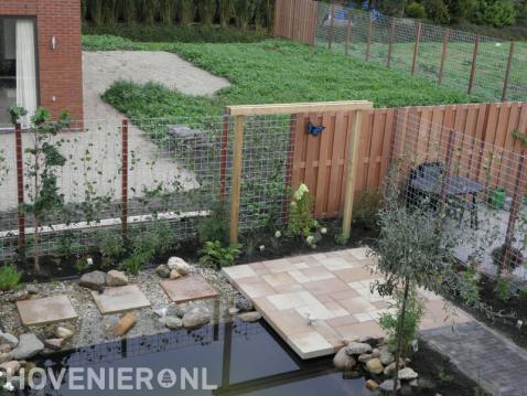Tuin met vijver, pergola's en schutting van betongaas met klimop 3