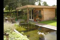 Houten tuinhuis met overkapping bij vijver