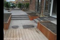 Trappetjes en hardhouten plantenbakken in tuin met hoogteverschillen
