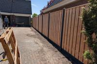 Houtbetonschutting redwood panelen met antraciet palen en onderplaat