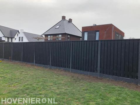 Plaatsen van een hout beton schutting van donker hout