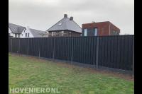 Plaatsen van een hout beton schutting van donker hout