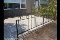 Voortuin met bestrating, sierhekwerk en hedera schutting