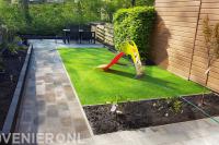Tuinaanleg met bestrating, kunstgras en plantenbak