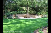 Zitkuil met houten bankje rondom boom