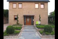 Onderhoudsvriendelijke voortuin met plantenbakken en buxus