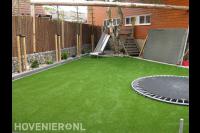 Achtertuin met kunstgras en ingebouwde trampoline