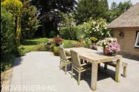 Terras met houten tuintafel en tuinstoelen
