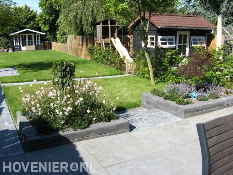 Smalle lange tuin met gazon en tuinhuis