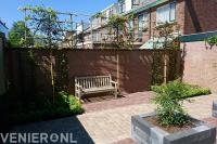 Tuin met plantenbakken van stapelblokken en leibomen 2