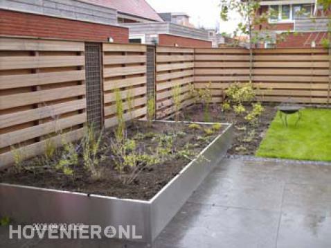 Tuinaanleg met houten schutting, gazon, bestrating en beplanting