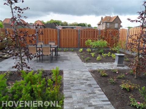 Achtertuin met hout beton schutting en terras met tuinmeubels