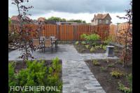Achtertuin met hout beton schutting en terras met tuinmeubels