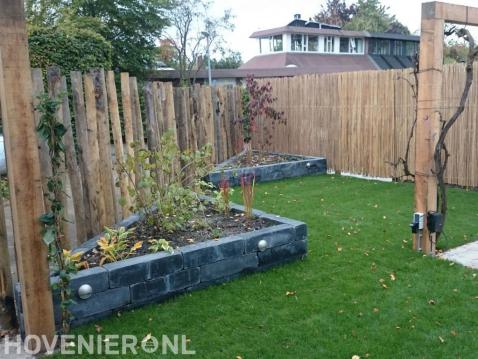 Tuin met gazon, pergola en borders van stapelblokken