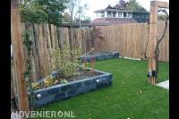 Tuin met gazon, pergola en borders van stapelblokken