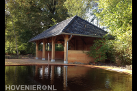 Grote houten overkapping met pannendak bij vijver